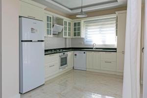 a kitchen with white appliances and a white refrigerator at Paradise Town Villa Belhamra in Belek