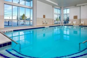 a swimming pool with blue water in a building at SpringHill Suites by Marriott Boston Logan Airport Revere Beach in Revere
