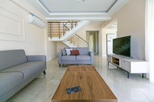 a living room with a couch and a tv at Paradise Town Villa Belhamra in Belek
