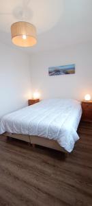 - une chambre avec un lit blanc et une lampe dans l'établissement Valparaiso-Vue Mer-2 ch-Garage-Sables d olonne, à Les Sables-dʼOlonne