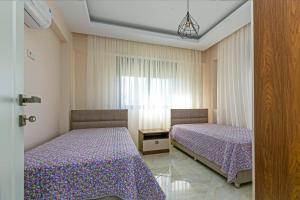 a bedroom with two beds and a window at Paradise Town Villa Belhamra in Belek +57 photos
