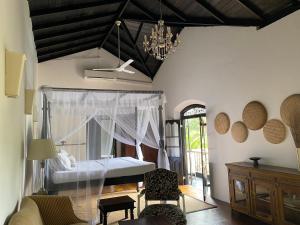 a bedroom with a bed and a chandelier at Galle Henna Estate in Unawatuna
