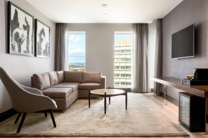 a living room with a couch and a tv at AC Hotel by Marriott Belfast in Belfast