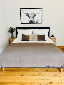 a bedroom with a large bed with a cow on the wall at Apartment Traumblick Berggipfel in Vordernberg