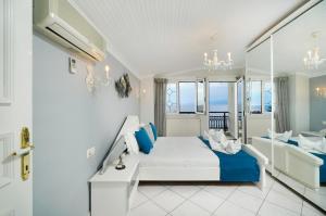 a white bedroom with a bed and a balcony at Villa Le Tresor in Skala Kallirakhis