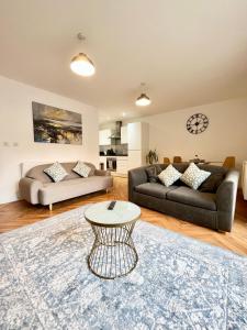 a living room with a couch and a table at 2 Double beds OR 4 Singles, 2 Bathrooms, FREE PARKING, Smart TV's, Close to Gunwharf Quays, Beach & Historic Dockyard in Portsmouth