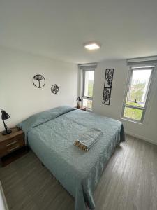 ein Schlafzimmer mit einem Bett und zwei Fenstern in der Unterkunft Moderno Apartamento #1 Excelente ubicación in Punta del Este