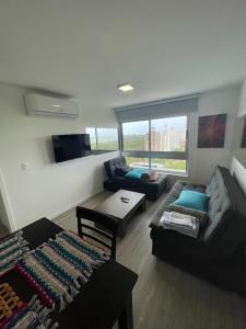 ein Wohnzimmer mit einem Sofa und einem Tisch in der Unterkunft Moderno Apartamento #1 Excelente ubicación in Punta del Este