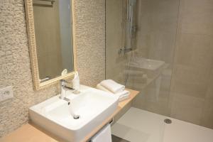 La salle de bains est pourvue d'un lavabo, d'un miroir et d'une douche. dans l'établissement Bed&Bike Berliner Hof, à Saint-Vith