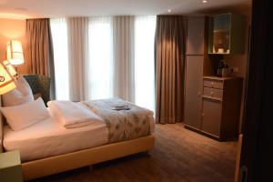 una camera d'albergo con un letto e una grande finestra di Bed&Bike Berliner Hof a Saint-Vith