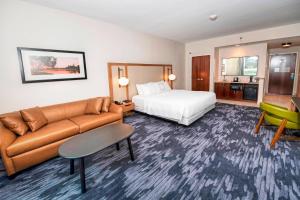 a hotel room with a bed and a couch at Fairfield Inn & Suites by Marriott Ottawa Airport in Ottawa