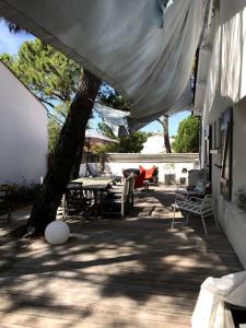 a patio with a table and chairs and a tree at VILLA 'Le Refuge' Piscine chauffée 300 m plage in La Tranche-sur-Mer