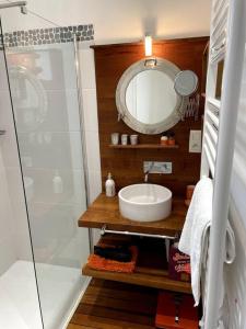 a bathroom with a sink and a mirror at VILLA 'Le Refuge' Piscine chauffée 300 m plage in La Tranche-sur-Mer