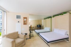 a bedroom with a bed and a couch and a chair at Ilikai Marina 985 in Honolulu