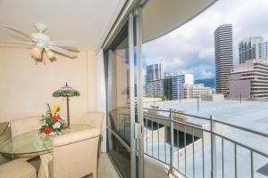 a balcony with a glass table and a view of the city at Ilikai Marina 985 in Honolulu