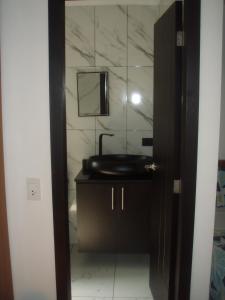 a bathroom with a black sink and a mirror at Hostal Limoncocha in Tena