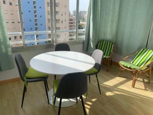 stół i krzesła w pokoju z oknem w obiekcie SERVICE APART LAZARO- Apartamentos Aguamarina 58 w mieście Calpe