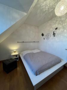 a bedroom with a white bed in a attic at Le Repaire des Bolides - 24H du Mans - 6p - Wi-Fi 