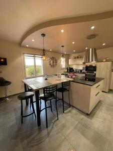 a kitchen with a table and chairs in a room at Le Repaire des Bolides - 24H du Mans - 6p - Wi-Fi 