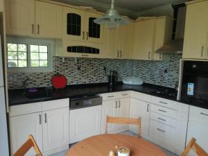 a kitchen with white cabinets and a wooden table at Rada Home in Marmaris