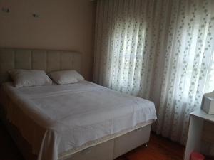 a bedroom with a white bed with curtains and a window at Rada Home in Marmaris +8 photos