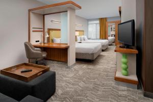 a hotel room with two beds and a flat screen tv at SpringHill Suites Potomac Mills Woodbridge in Woodbridge