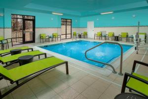 席爾瓦普拉納的住宿－波托馬克米爾斯普林希爾套房酒店，一个带绿色桌椅的大型游泳池