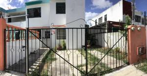 una puerta negra frente a un edificio blanco en Depto Duplex Cancún (Cuarto) en Cancún