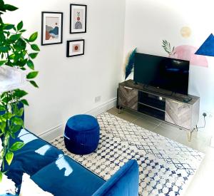 a living room with a blue couch and a tv at Cosy One Bedroom Apartment in Trowbridge