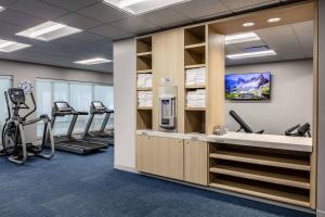 una sala de fitness con cintas de correr y máquinas elípticas en TownePlace Suites By Marriott Milwaukee West Bend, en West Bend