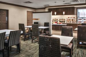 a dining room with tables and chairs and a kitchen at Residence Inn Pittsburgh Cranberry Township in Cranberry Township