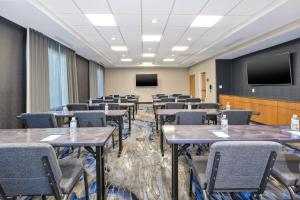 a conference room with tables and chairs and a screen at Fairfield Inn & Suites by Marriott Cincinnati Airport South/Florence in Florence