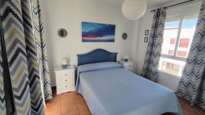 コニル・デ・ラ・フロンテーラにあるVerdeMar-Terraza-Sólo familiasの青いベッドと窓付きの小さなベッドルームが備わります。