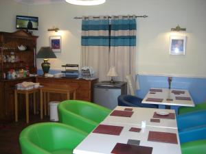 a room with two tables and green chairs at Lynebank House Hotel, Bed & Breakfast in Carlisle