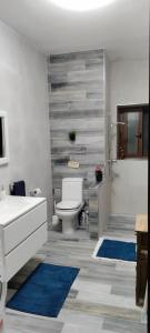 uma casa de banho com um WC branco e tapetes azuis em Homestay Naxxar em Naxxar