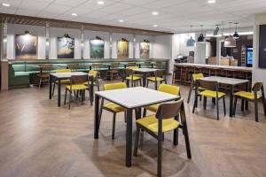een restaurant met tafels en gele stoelen en een bar bij Fairfield Inn & Suites by Marriott Indianapolis Greenfield in Greenfield