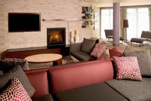a living room with a couch and a fireplace at Courtyard By Marriott Sioux Falls in Sioux Falls