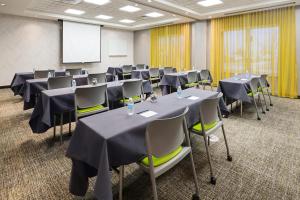 a conference room with tables and chairs and a screen at SpringHill Suites by Marriott Denver Airport in Denver