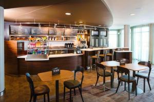 a restaurant with tables and chairs and a bar at Courtyard By Marriott Sioux Falls in Sioux Falls