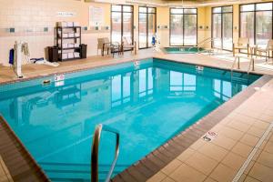 a large swimming pool with blue water in a building at Courtyard By Marriott Sioux Falls in Sioux Falls