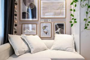 a white couch in a room with pictures on the wall at Ocean Breeze Suite 1min to Beach in Kos Town