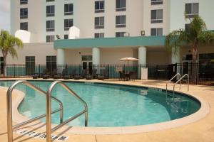 a large swimming pool in front of a building at SpringHill Suites Orlando Airport in Orlando