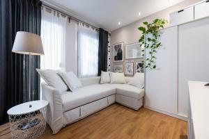 a white living room with a white couch and a table at Ocean Breeze Suite 1min to Beach in Kos