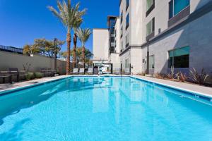 a swimming pool in front of a building with palm trees at TownePlace Suites by Marriott San Diego Central in San Diego