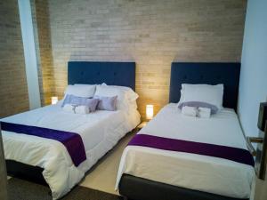 dwa łóżka siedzące obok siebie w pokoju w obiekcie Hotel Boutique M w mieście Barranquilla