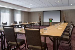 a conference room with a long table and chairs and a screen at Courtyard by Marriott Houston Northwest/Cypress in Cypress