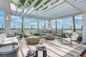 d'une terrasse avec des canapés, des tables et des palmiers. dans l'établissement Courtyard by Marriott Fort Lauderdale Downtown, à Fort Lauderdale