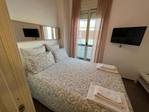 a bedroom with a bed with a tv on the wall at Ortigia D'aMare Apartment in Siracusa