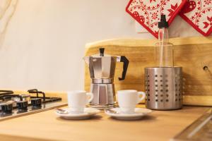eine Kaffeemaschine und zwei Tassen auf einer Küchentheke in der Unterkunft La Casa di Annale' in Gallipoli