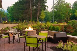 un patio con mesas, sillas y una hoguera en SpringHill Suites by Marriott Seattle Issaquah, en Issaquah